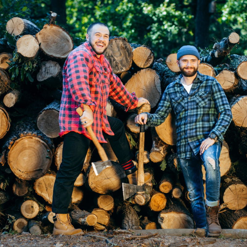 two bearded men cutting wood logs
